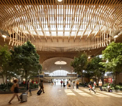 Indoor view of PDX's new massive airport terminal with a wooden beamed roof and skylight.