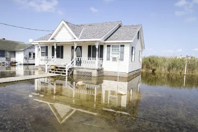 White house surrounded by several inches of tidal floodwaters.