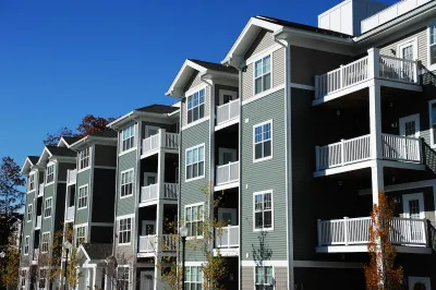 Four-story apartment building with gabled roofs.