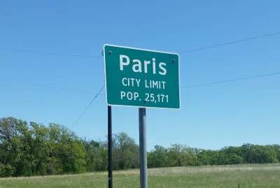 Green Paris Texas city limit sign with population.