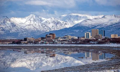 Anchorage, Alaska skyline with snowy mountains in background.