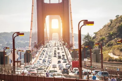 View of traffic on Golden Gate Bridge at sunset.
