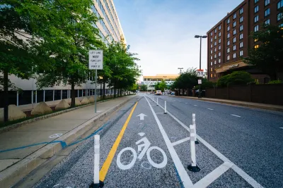 Bike lane protected by plastic delineators on street in downtown Baltimore, Maryland.