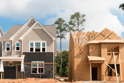 Two wood-frame houses under construction.