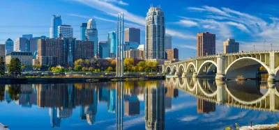 Minneapolis, Minnesota skyline with river and bridge in foreground.