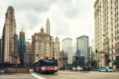 Public transit bus on Chicago street with tall historic buildings in background.
