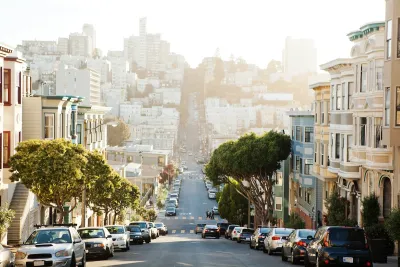 View down San Francisco street downhill with cars parked on both sides.
