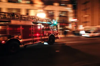 Chicago fire department fire truck driving down street with blurred background indicating motion at nighttime.