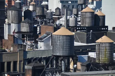 Old water towers on dense New York City rooftops.