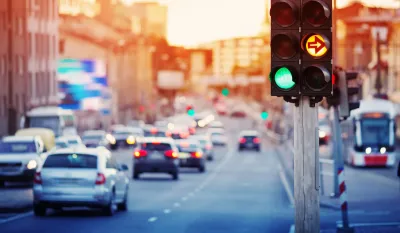 Traffic light with blurred cars and streetcar in background.