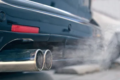 Close-up of car tailpipe emitting white smoke