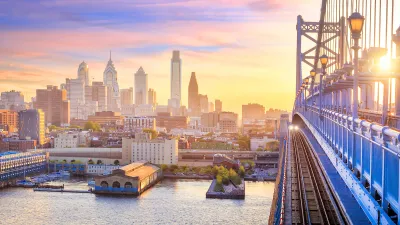 Phialdelphia skyline at sunset with close-up of bridge in foreground.