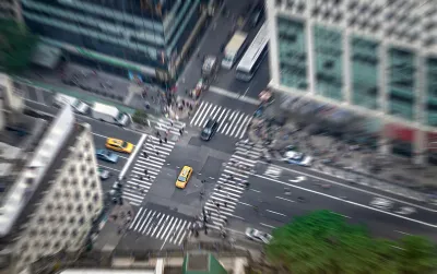 Aerial view of intersection in New York City with yellow cabs and zebra crosswalks.