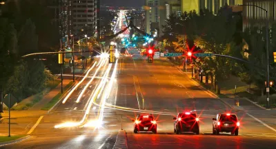 Three cars stopped at a traffic light in downtown Salt Lake City, Utah at night.