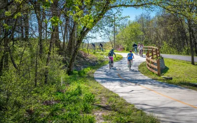 People biking on paved bike trail in Arkansas.