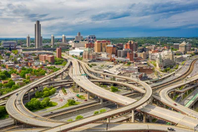 Aerial view of highways and downtown Albany skyline.