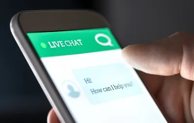 View of a phone with a chatbot interface asking user how it can help them.