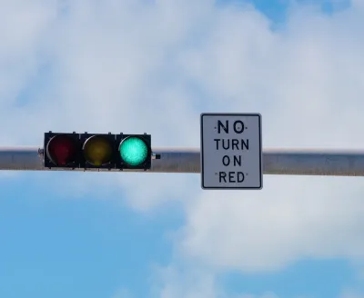 Overhead traffic light with green light on and white "No turn on red" sign.