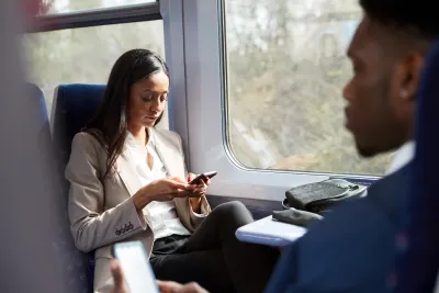 Close-up of two passengers in business clothes sitting face to face on speeding train