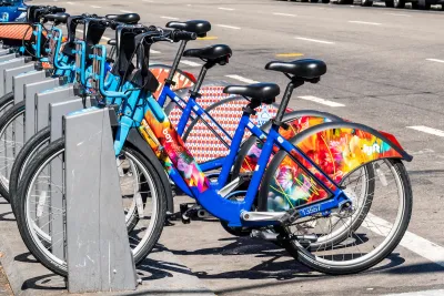 Bay Wheels bike share station full of colorful parked bikes on San Francisco street.