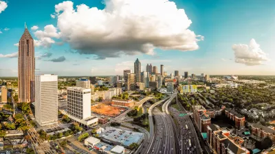 Birds-eye view of Atlanta skyline and highway running through the middle of it.