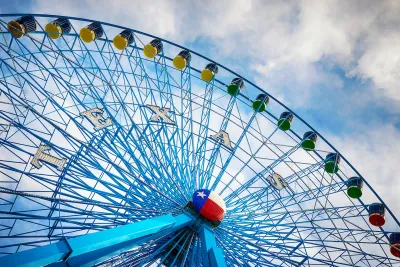 Blue Ferris wheel with Texas state Lone Star logo in middle of wheel.