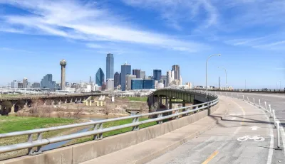 Separated protected bike lane on highway leading toward downtown Dallas, Texas.