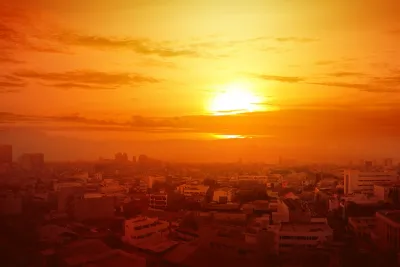 View of city skyline with orange sky indicating extreme heat.