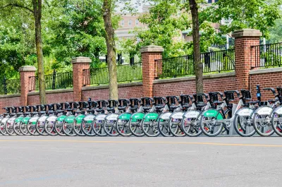 Long row of Bixi bike share bikes parked at station on street in Montreal, Canada.