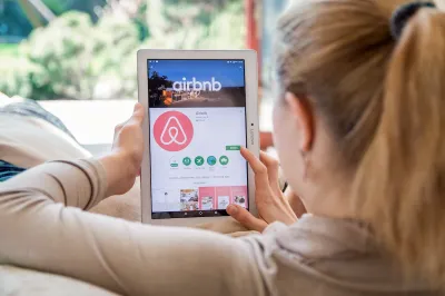 Blonde woman looking for rental on Airbnb app on tablet.