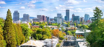 View of Portland skyline with green trees in foreground.