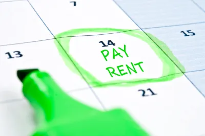 Close-up of calendar with "Pay rent" written on day 14 and circled in green highlighter