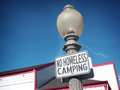 "No homeless camping" sign on a light post