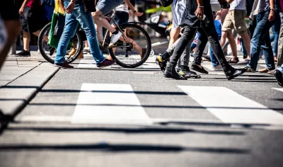 Low angle view of busy crosswalk with pedestrians and a bike.