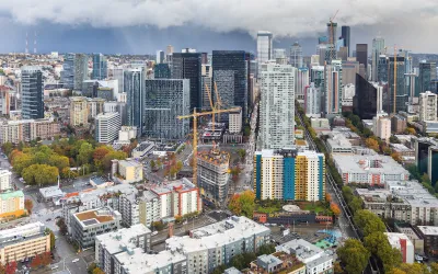 View of downtown Seattle with construction cranes and cloudy sky as seen from top of Space Needle.