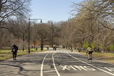People walking and on bikes on paved multiuse path in Prospect Park, Brooklyn, New York City.