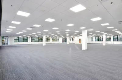 Large empty office building floor with white walls and grey carpeting
