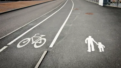 Bike land and pedestrian lane marked with white paint on grey asphalt
