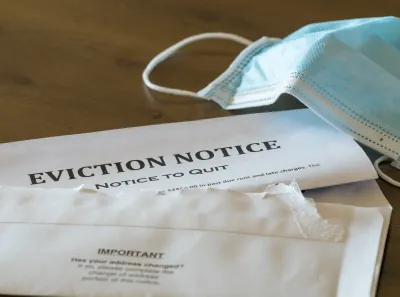 Eviction notice on table with surgical face mask lying next to it.