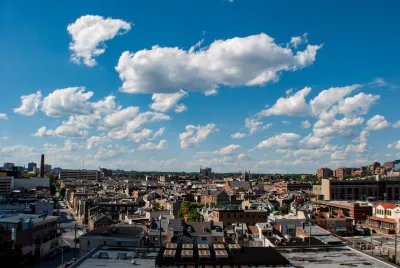View of east Baltimore, Maryland low-slung brick buildings against a lightly cloudy blue sky