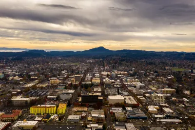 Aerial view of Eugene, Oregon at dusk with mountains in background.