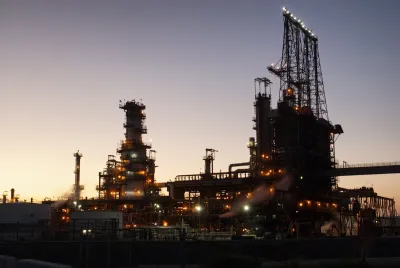 Oil refinery sillhouetted against evening sky.