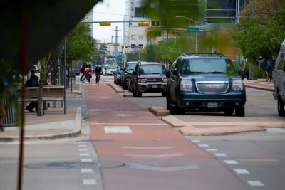 Red painted and curb-protected bike lane in downtown Austin, Texas.