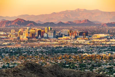 Skyline of Phoenix, Arizona with mountains in background at dawn or dusk.
