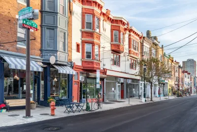 Row of three-story buildings with stores and restaurants with awnings on ground floor in Philadelphia, Pennsylvania.