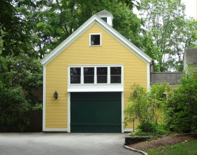Yellow converted garage with green door and white-framed windows.
