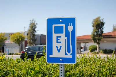 Blue sign with white gas pump symbol with electric plug and "EV"