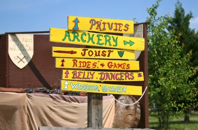 Signpost with signs for archery, jousting, privies, etc at Renaissance faire