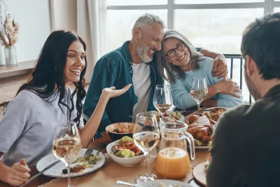 Multi-generational white family sits around dining table