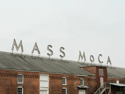 Sign for MASS MoCA on brick building.